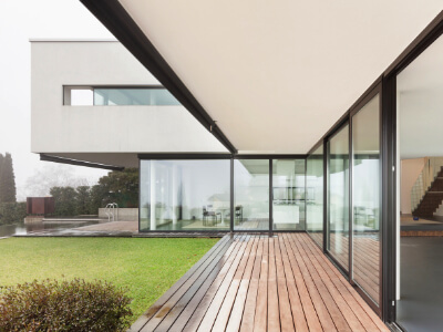 Modern home with full glass windows overlooking backyard.