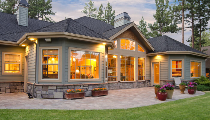 Residential windows reflecting the evening sky and overlooking the backyard.